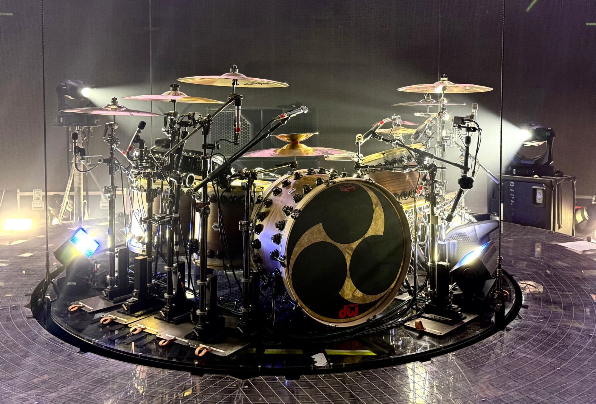 Tommy Lee's DW drum kit on a circular riser, backlit by stage lights on the Mötley Crüe 2026 tour